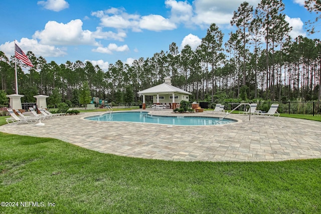 view of pool with a lawn and a patio