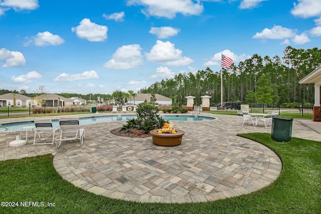 view of swimming pool with a patio and a fire pit