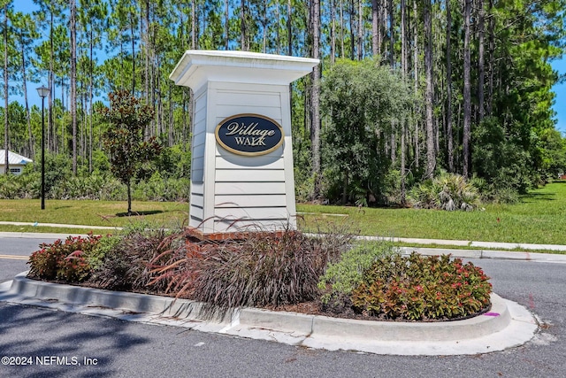 community / neighborhood sign featuring a lawn