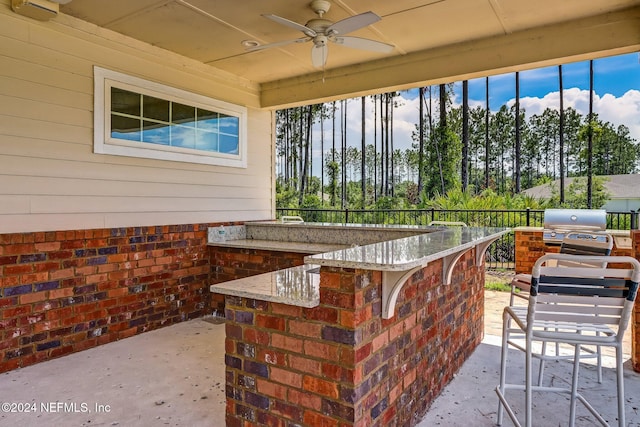 view of patio / terrace featuring an outdoor bar, area for grilling, and ceiling fan