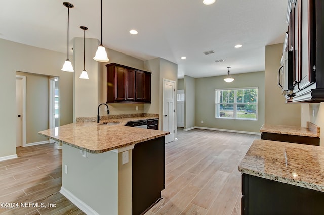 kitchen with light hardwood / wood-style floors, sink, light stone countertops, and hanging light fixtures