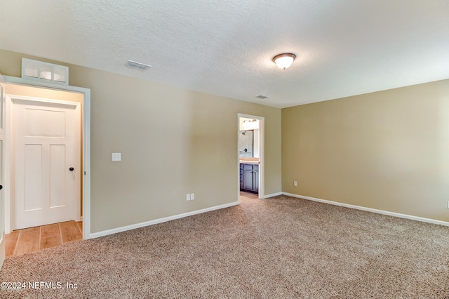 carpeted spare room with a textured ceiling