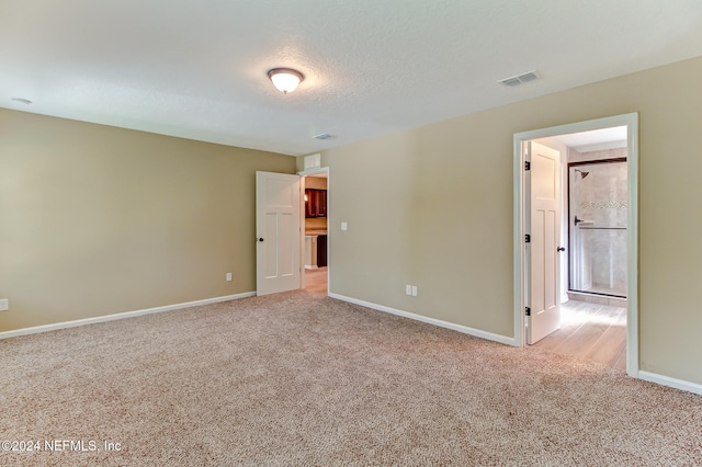 carpeted empty room with a textured ceiling