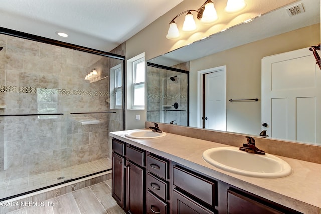 bathroom featuring vanity, wood-type flooring, and walk in shower