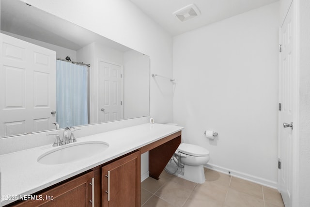 bathroom featuring toilet, vanity, baseboards, visible vents, and tile patterned floors