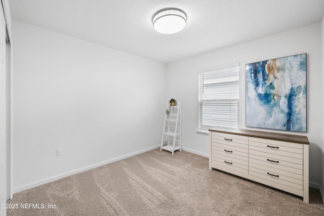 unfurnished bedroom with baseboards and light colored carpet