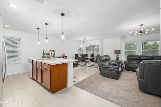 kitchen with a sink, dishwasher, an island with sink, an inviting chandelier, and pendant lighting