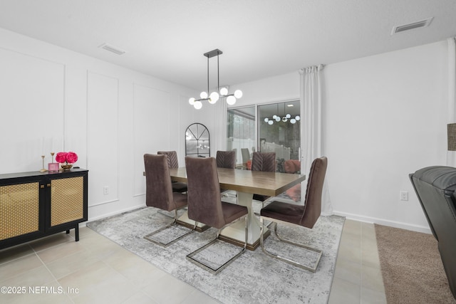 dining area featuring an inviting chandelier, visible vents, and a decorative wall