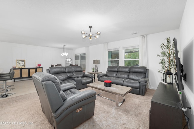 living room featuring a notable chandelier, light tile patterned floors, visible vents, light carpet, and a textured ceiling