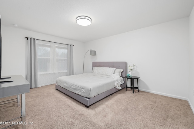 bedroom with light carpet and baseboards