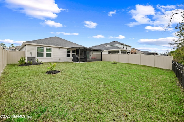 back of property featuring a sunroom, a fenced backyard, a yard, and central AC unit