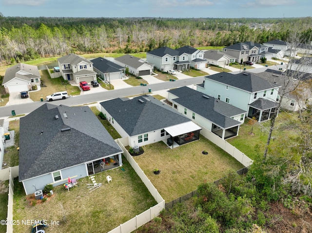 drone / aerial view featuring a forest view and a residential view