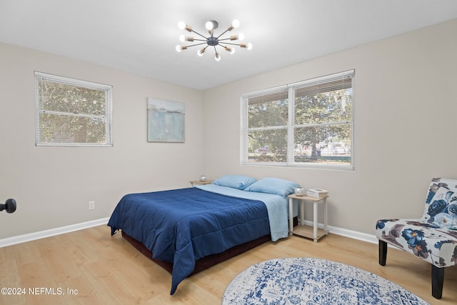 bedroom featuring wood-type flooring and a notable chandelier