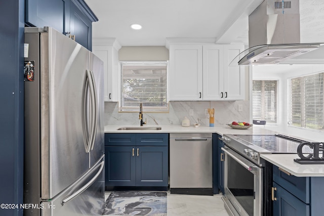 kitchen with blue cabinetry, sink, tasteful backsplash, exhaust hood, and appliances with stainless steel finishes