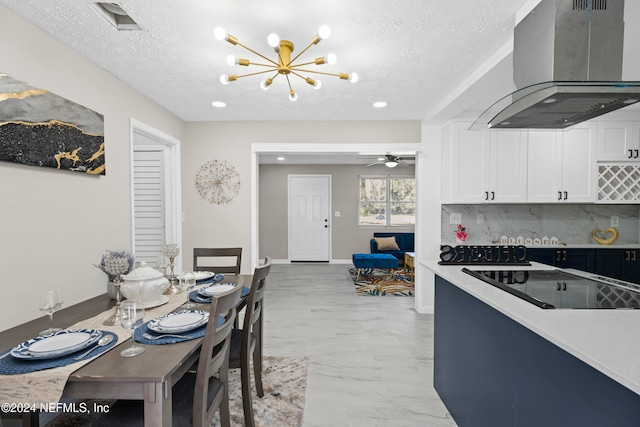 kitchen featuring backsplash, wall chimney range hood, black electric cooktop, a textured ceiling, and white cabinetry