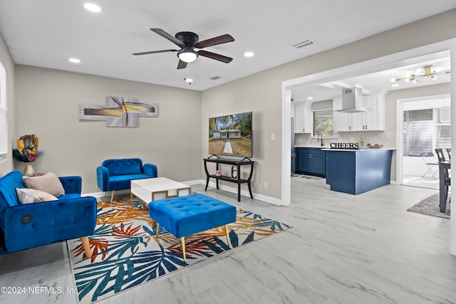 living room featuring ceiling fan and sink