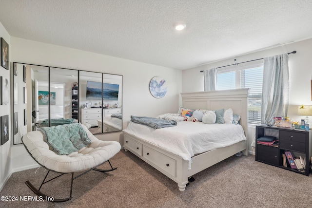 bedroom featuring a textured ceiling and carpet floors