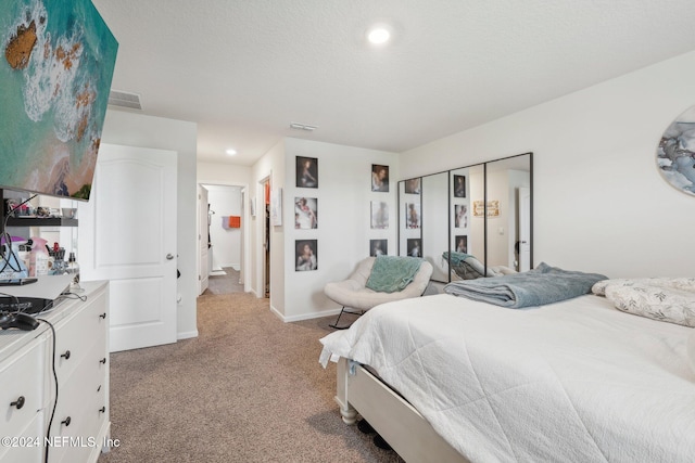 carpeted bedroom featuring a textured ceiling and a closet