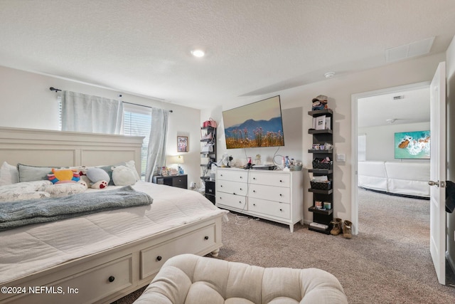 bedroom with light carpet and a textured ceiling