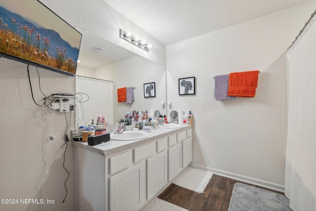 bathroom featuring hardwood / wood-style flooring, vanity, and a textured ceiling