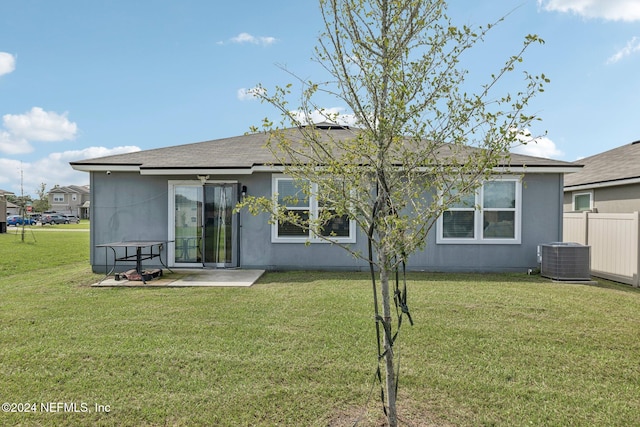 rear view of property featuring a patio area, central air condition unit, and a yard