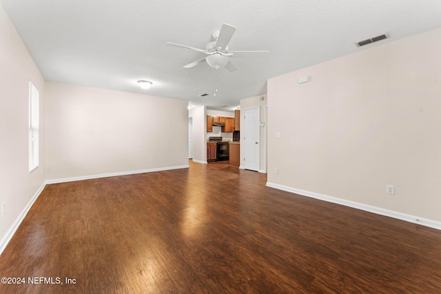 unfurnished living room with ceiling fan, dark hardwood / wood-style flooring, and a textured ceiling