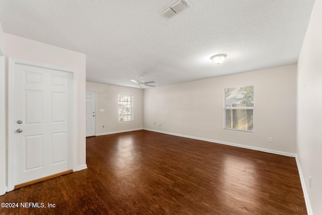 spare room with a textured ceiling, dark hardwood / wood-style flooring, and ceiling fan