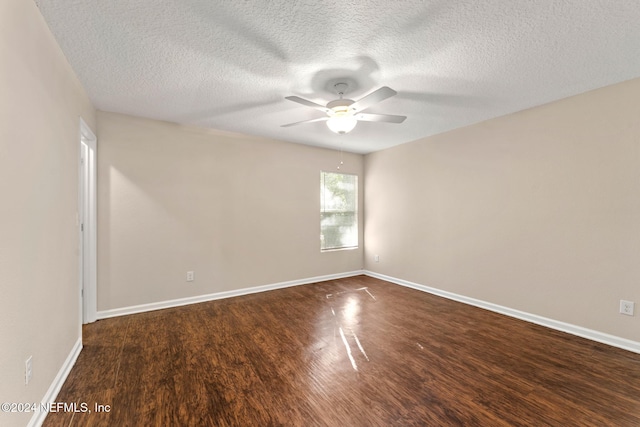 empty room with a textured ceiling, dark hardwood / wood-style floors, and ceiling fan