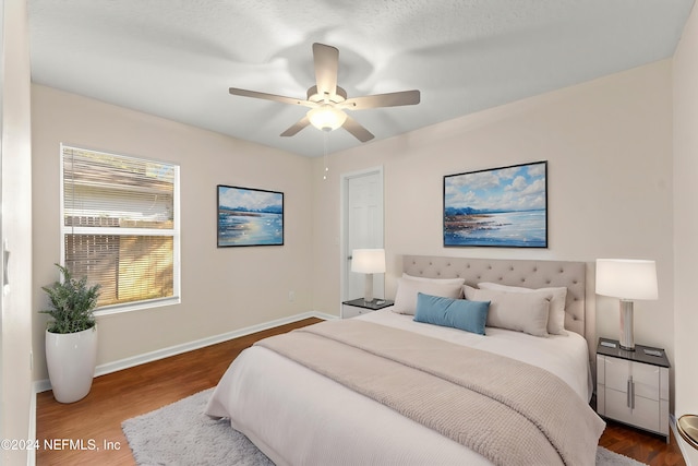 bedroom featuring hardwood / wood-style flooring, ceiling fan, and a textured ceiling