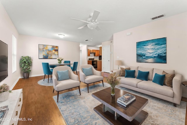 living room with ceiling fan and light hardwood / wood-style flooring