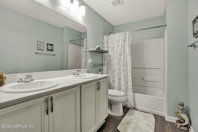 full bathroom with a textured ceiling, toilet, vanity, shower / tub combo, and hardwood / wood-style flooring