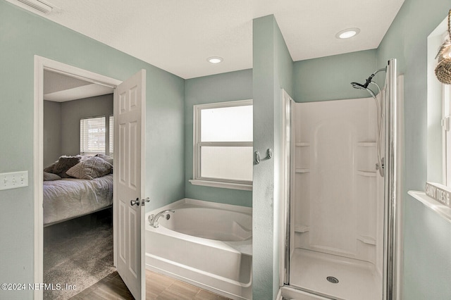 bathroom featuring wood-type flooring and shower with separate bathtub