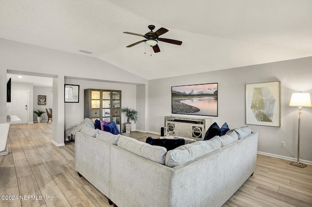 living room featuring light wood-type flooring, vaulted ceiling, and ceiling fan