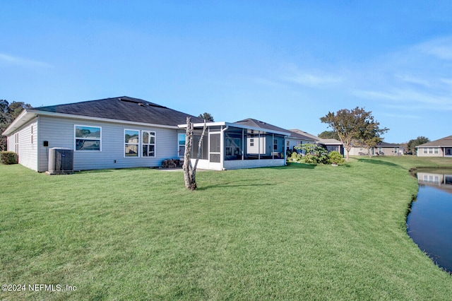 rear view of house featuring a lawn, central AC, and a sunroom