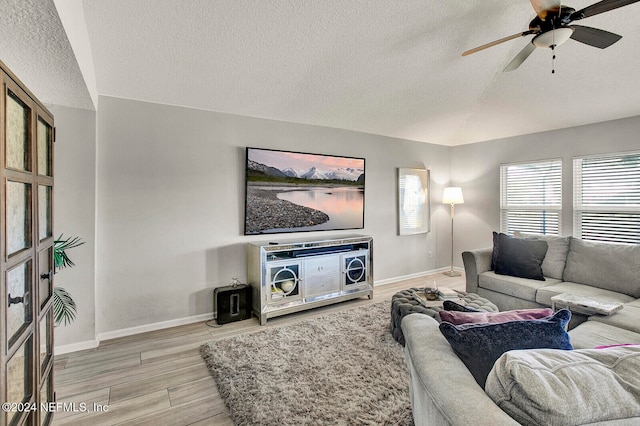 living room with a textured ceiling, hardwood / wood-style flooring, and ceiling fan