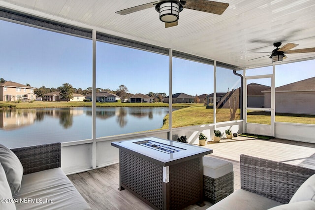 sunroom / solarium featuring a water view and ceiling fan