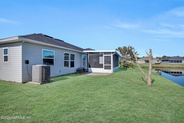 back of house with a sunroom, a lawn, and central AC