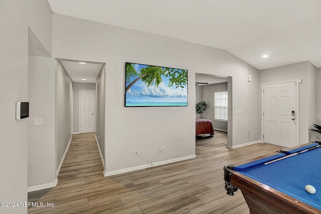 playroom with hardwood / wood-style floors, a textured ceiling, pool table, and vaulted ceiling