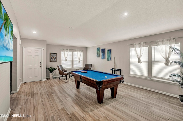 game room with light wood-type flooring, a textured ceiling, and pool table