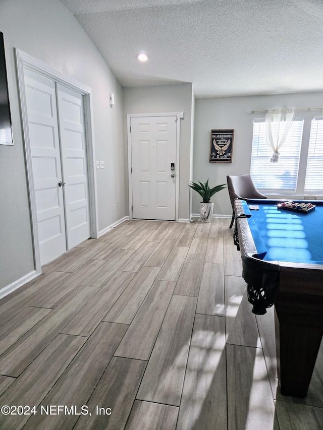 unfurnished office with billiards, a textured ceiling, and hardwood / wood-style flooring