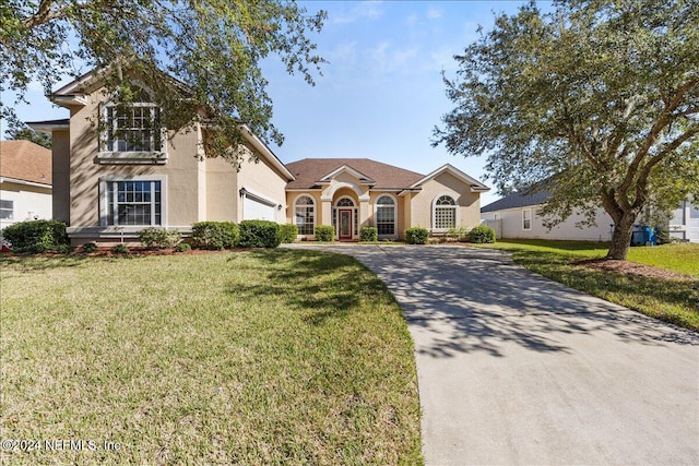 view of front of home with a garage and a front lawn