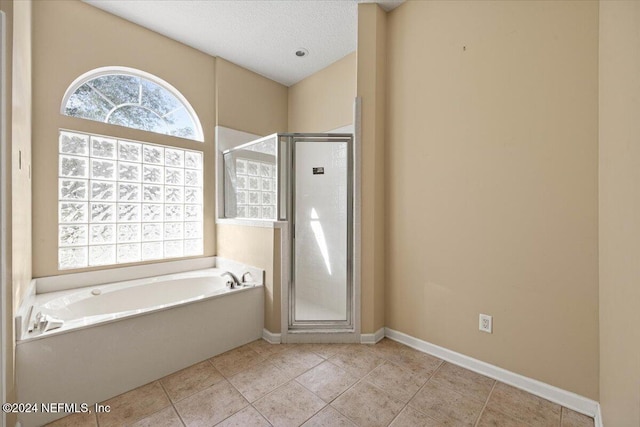 bathroom featuring tile patterned floors, shower with separate bathtub, and a textured ceiling