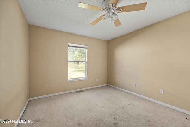 spare room featuring carpet, ceiling fan, and a textured ceiling