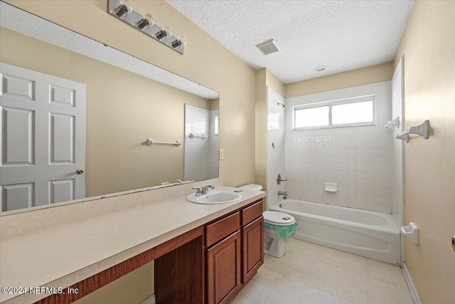 full bathroom featuring vanity, toilet, a textured ceiling, and tiled shower / bath combo