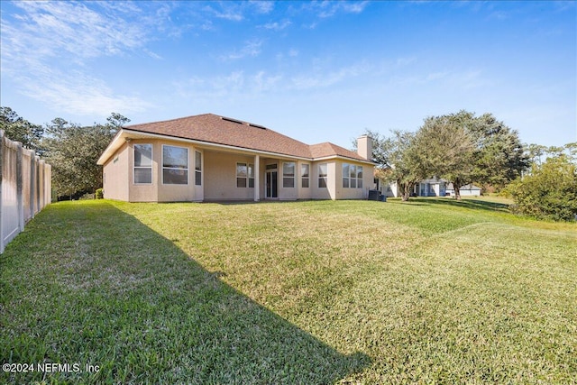 back of house featuring a lawn