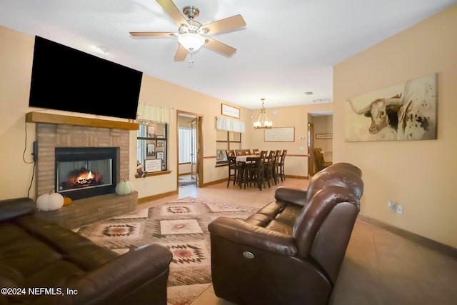 tiled living room with a tiled fireplace and ceiling fan with notable chandelier