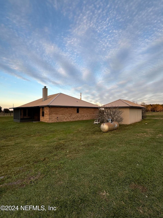 property exterior at dusk with a yard