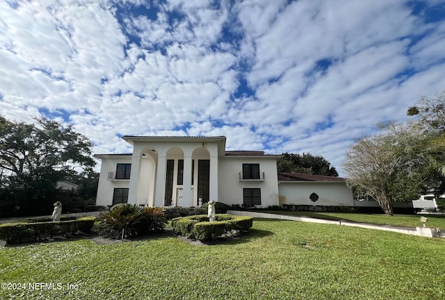 mediterranean / spanish house with a front lawn