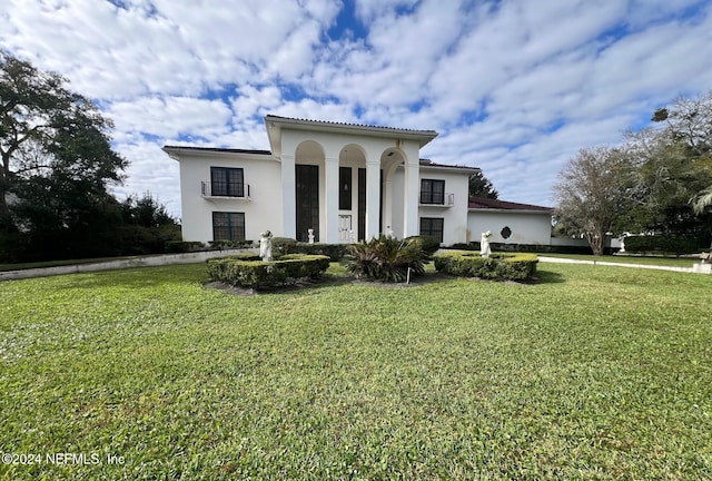 mediterranean / spanish home featuring a front lawn