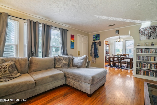 living room featuring hardwood / wood-style floors, plenty of natural light, crown molding, and a textured ceiling